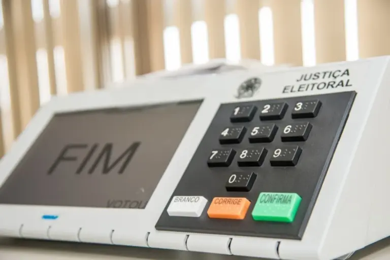 Urna eletrônica com teclado e tela de confirmação de voto.