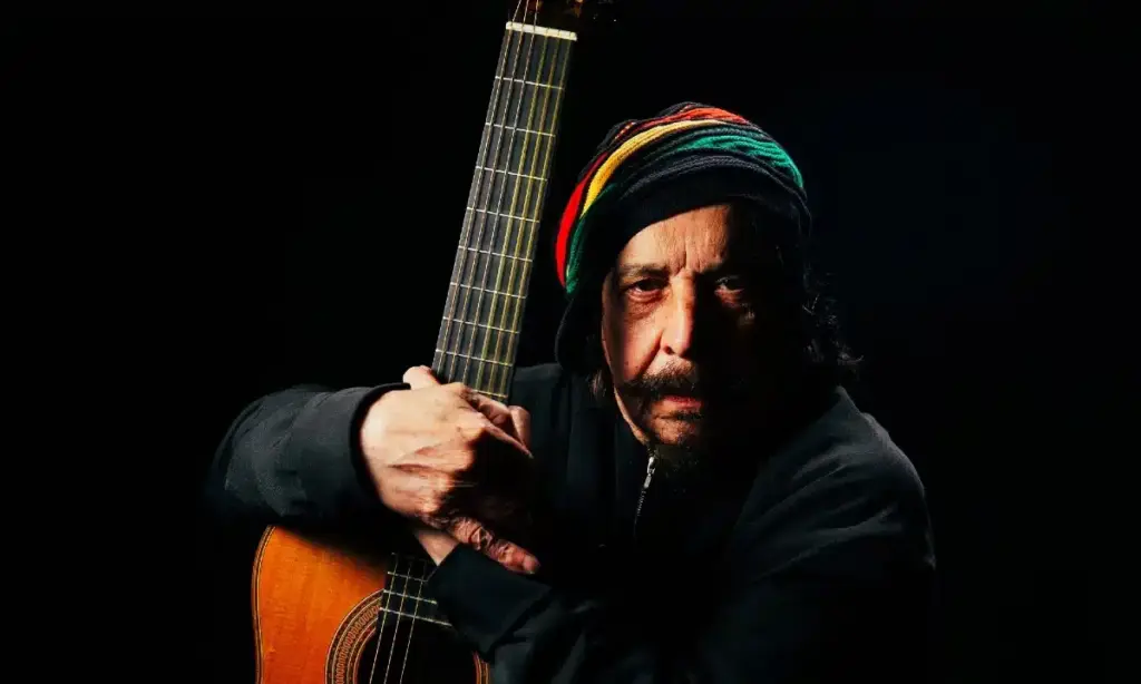 Benito di Paula sozinho, segurando um violão, em retrato de Murilo Alvesso.