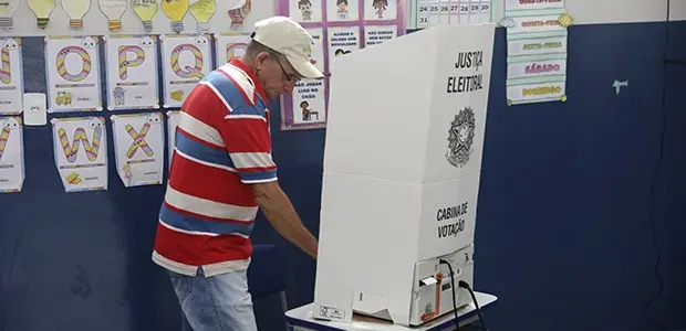 Eleitor vota em urna eletrônica na cabine de votação