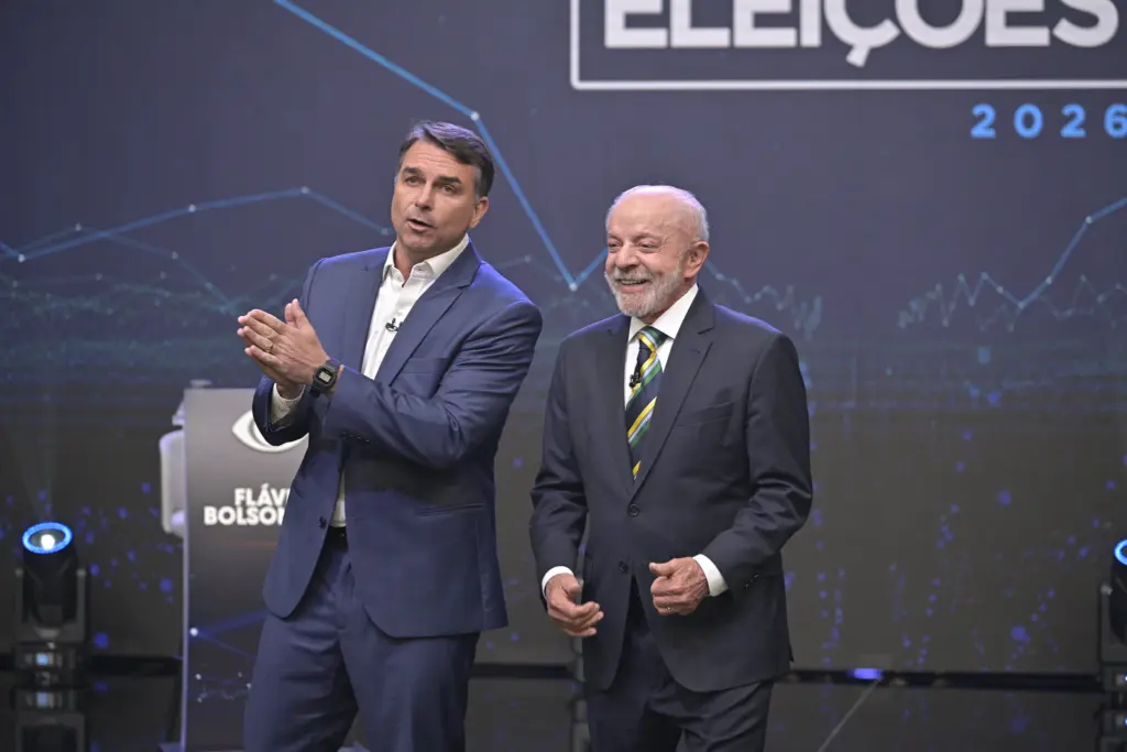 Flávio Bolsonaro e Lula lado a lado no palco do debate da Band, em 18 de outubro de 2026.
