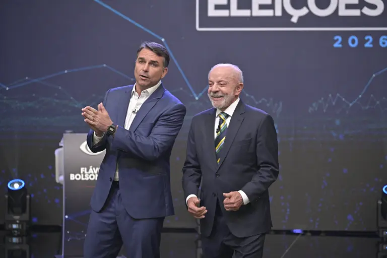 Flávio Bolsonaro e Lula lado a lado no palco do debate da Band, em 18 de outubro de 2026.