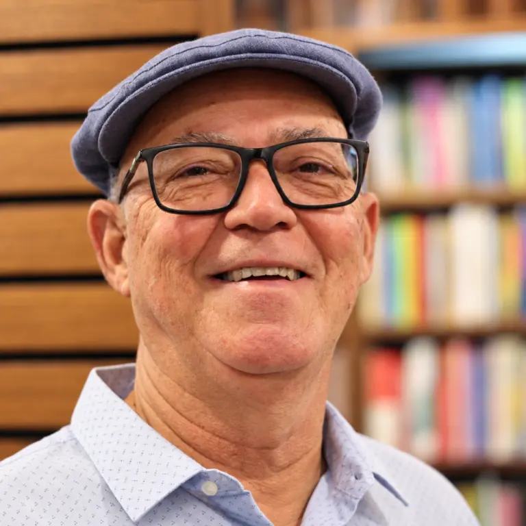 José Rosa Soares Filho, de boina e óculos, diante de uma estante de livros